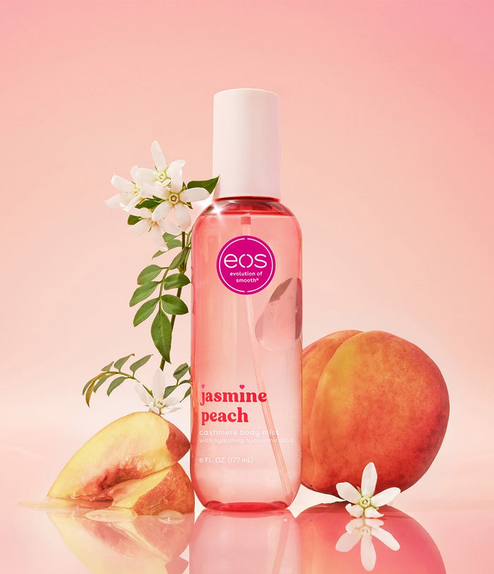 EOS Jasmine Peach body mist bottle with peaches and flowers on a pink background