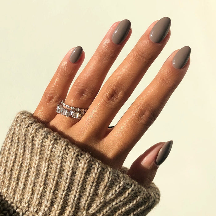 Traveler stoney taupe nail polish manicure on a medium skin tone with rings