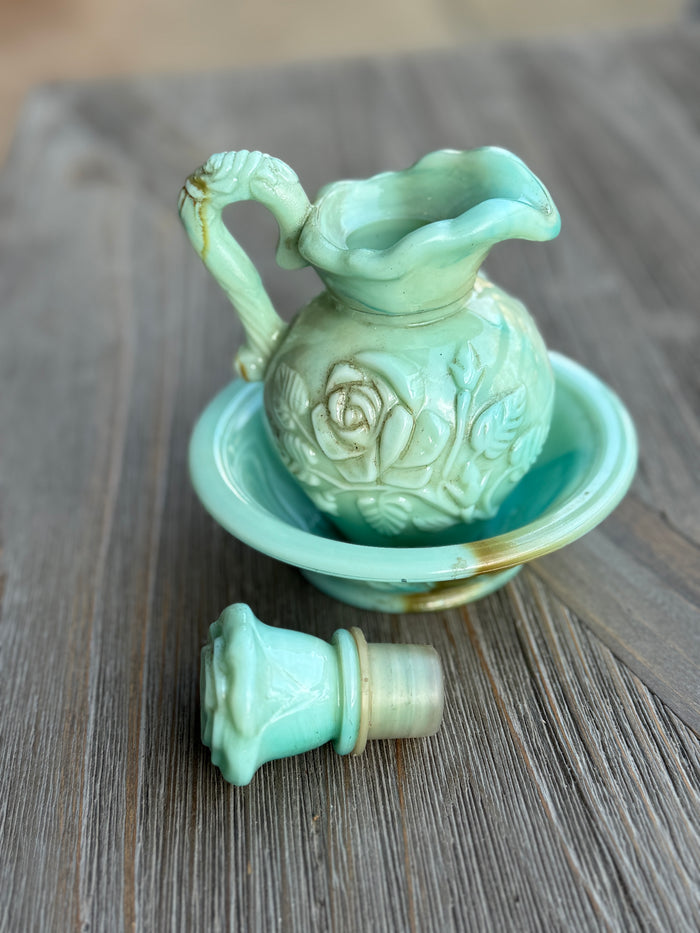 Light green ceramic pitcher with spout on a wooden surface