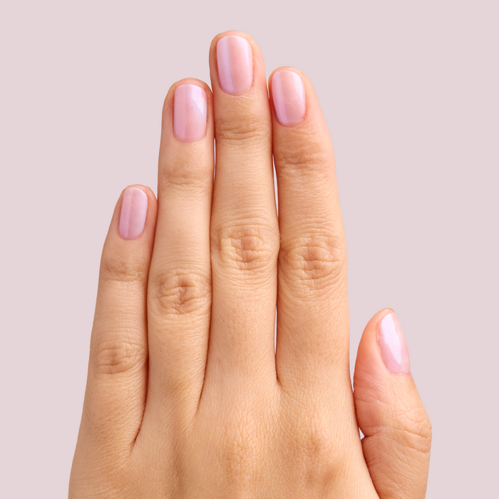 Hand with nails polished in soft pearly pink using BAROQUE Gel for a shiny at-home manicure look