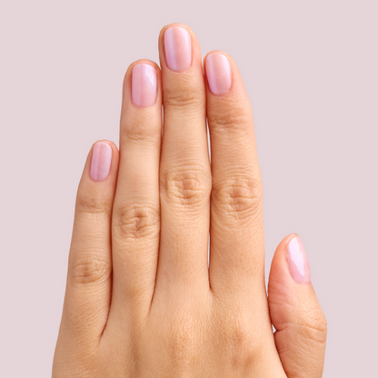 Hand with nails polished in soft pearly pink using BAROQUE Gel for a shiny at-home manicure look