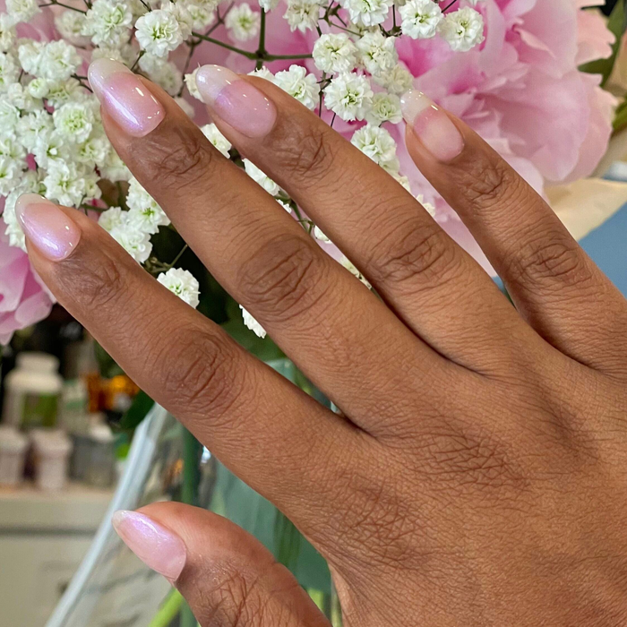 Hand with nails polished in soft iridescent pearly finish using BAROQUE Gel for a subtle long-lasting manicure