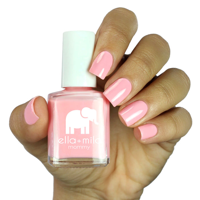 Blushing Dreams pastel bubblegum pink nail polish on a medium skin tone, hand holding the bottle