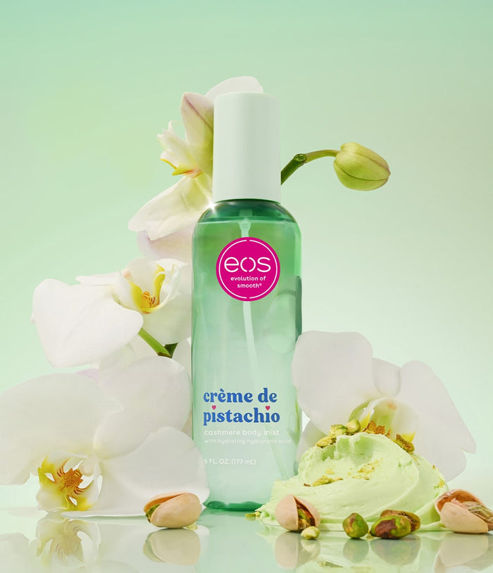 Green bottle of eos crème de pistachio with flowers and ice cream on a light green background