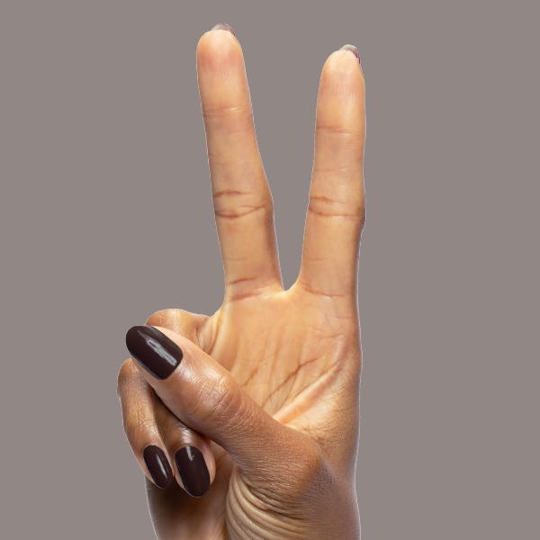 Hand with Dark Chocolate gel polish by Olive and June on medium-length rounded nails against plain background