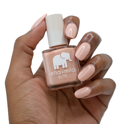 Global Goddess sandy nude nail polish on a deep skin tone, hand holding the bottle