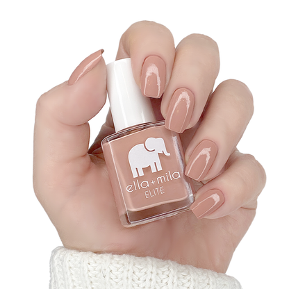 Global Goddess muted sandy nude nail polish manicure on a light skin tone with the bottle