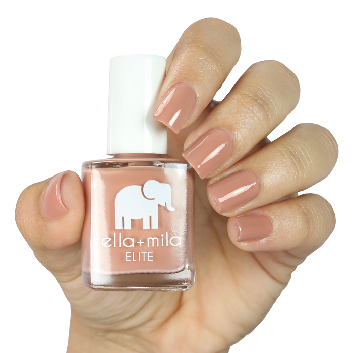 Global Goddess sandy nude nail polish on a medium skin tone, hand holding the bottle