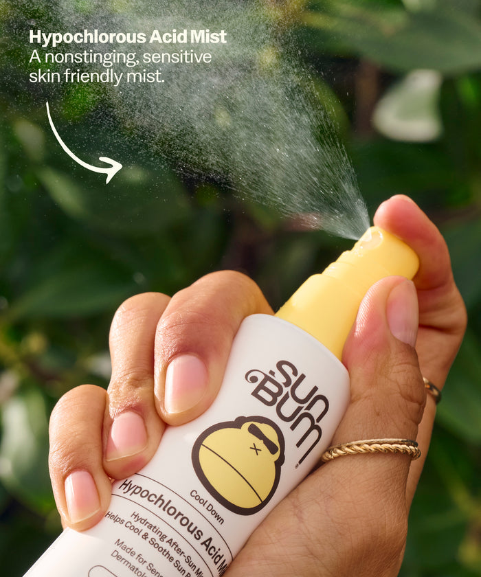 Hand holding Sun Bum Hypochlorous Acid Mist bottle spraying a gentle, nonstinging mist outdoors. Hypochlorous Acid Mist A nonstinging, sensitive skin friendly mist.