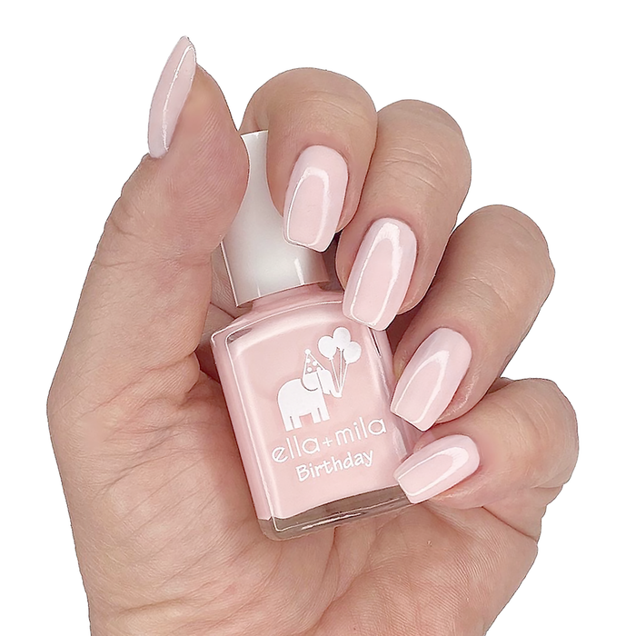 Lucky Seventh nude baby pink nail polish manicure on a light skin tone with the bottle