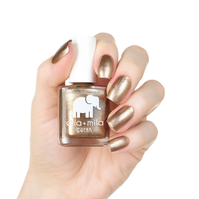 Mirage metallic gold nail polish manicure on a light skin tone with the bottle