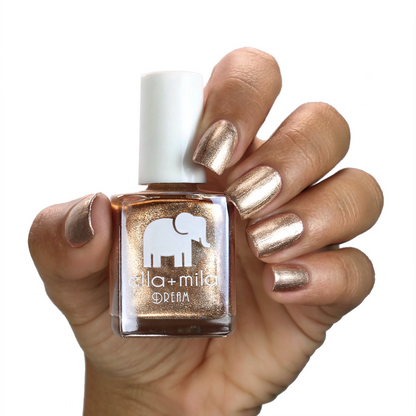 Mirage metallic gold nail polish on a medium skin tone, hand holding the bottle