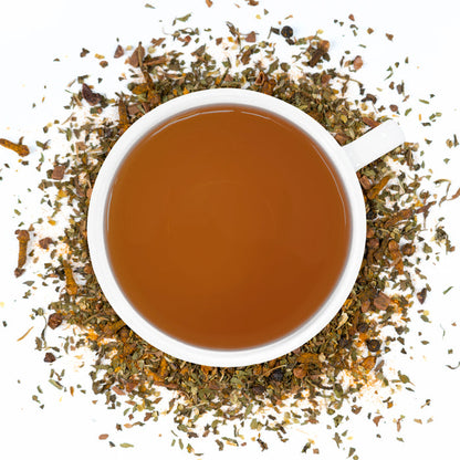 A white cup of Organic Antioxidant Boost Tea surrounded by the loose leaf blend.