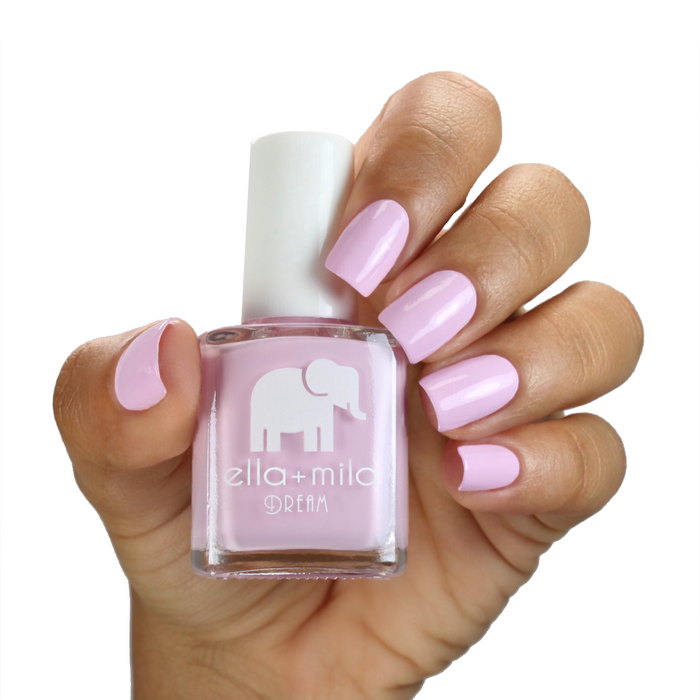 Serendipity pastel pink nail polish on a medium skin tone, hand holding the bottle