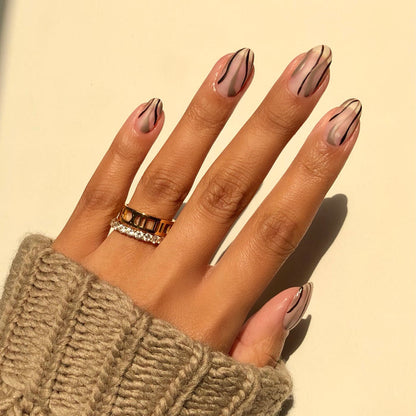 Traveler taupe outline French tip nail art on a medium skin tone with rings