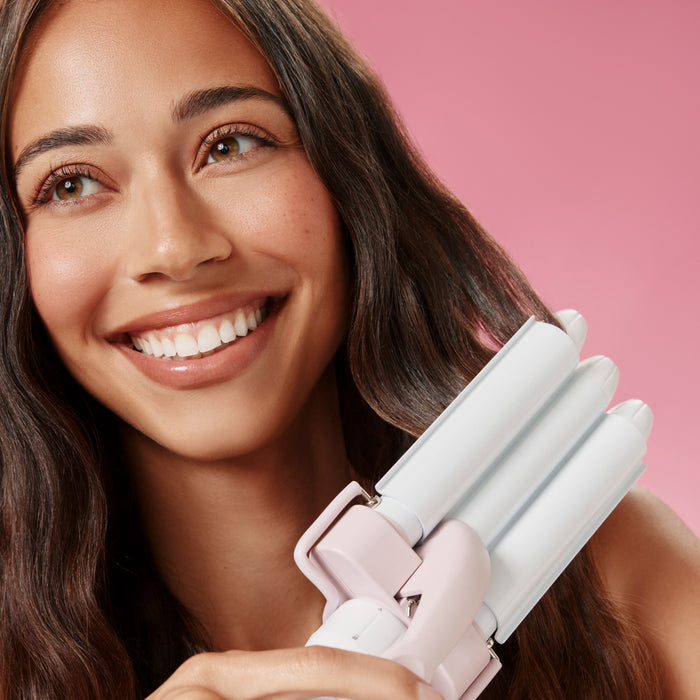 Woman using Triple Ripple Mini Waver against pink background